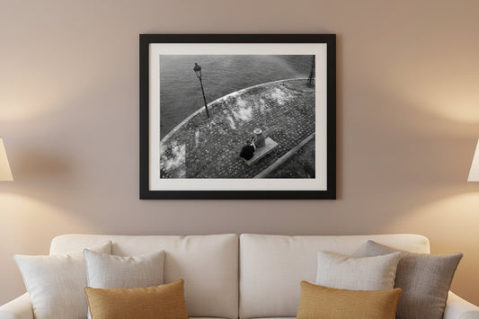 Framed black and white photograph on a wall above a sofa with decorative pillows.